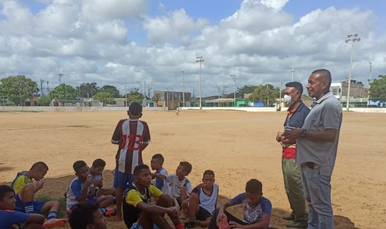 Entrenador Leonardo Melendrez con los jóvenes en una cancha de barrio Entrenador Leonardo Melendrez con los jóvenes en una cancha de barrio