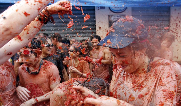 Varios jóvenes, durante la Tomatina en la calle principal de la localidad valenciana de Buñol.