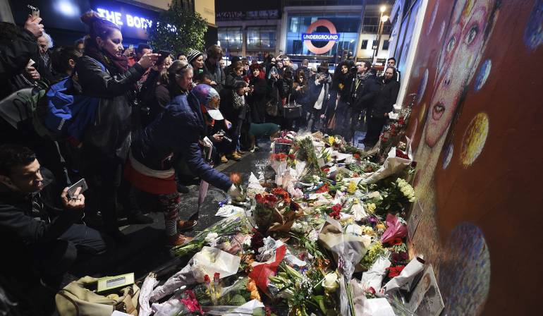 Varias personas riden homenaje al cantante británico David Bowie en el barrio donde creció, Brixton, de Londres.