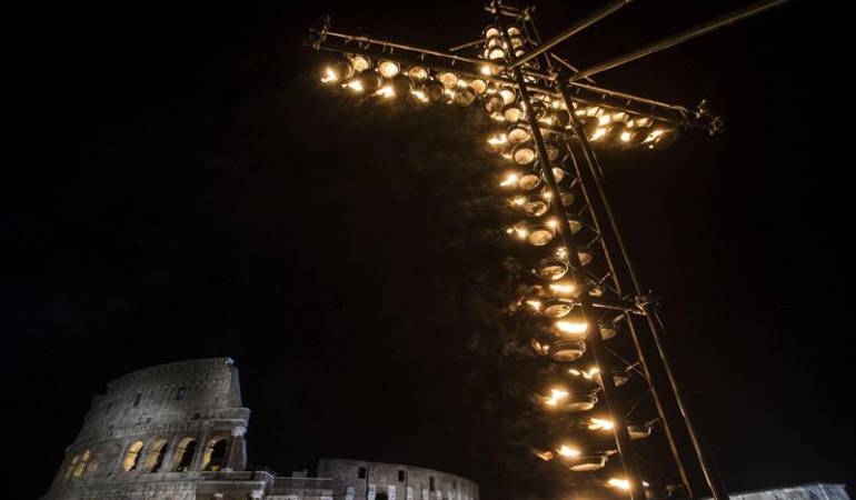 Unas lamparillas iluminan una cruz antes del inico del Vía Crucis delante del Coliseo en Roma (Italia).