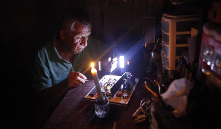 Un hombre repara un electrodoméstico durante un corte de luz en Venezuela
