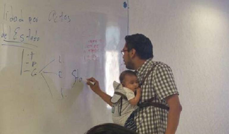 Profesor que cargó el bebé de su alumna: Profesor carga el bebé de una alumna para que ella tome apuntes de la clase