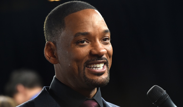 El actor Will Smith saluda a los medios de comunicación en un evento.