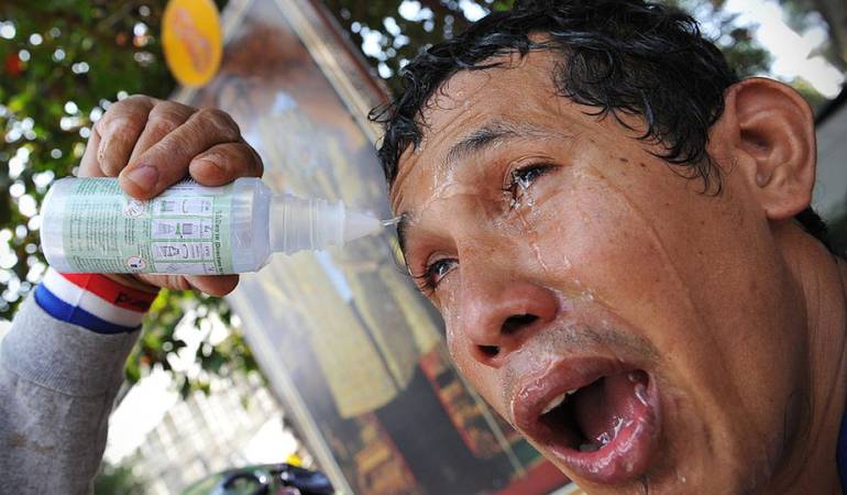 Un hombre trata de aliviar el efecto del gas lacrimógeno sobre sus ojos durante una manifestación antigubernamental en Bangkok, Tailandia, BANGKOK, en 2013.