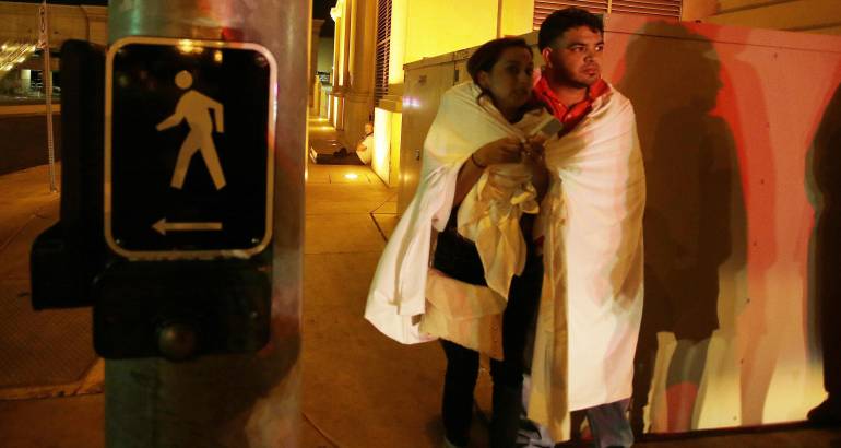 Varias personas permanecen a la entrada del hotel Mandalay Bay, cerca del lugar donde se produjo un tiroteo indiscriminado en Las Vegas, Estados Unidos