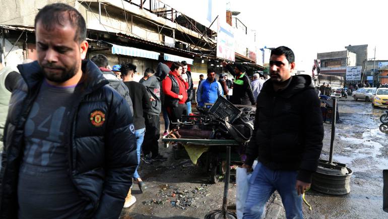 Iraquíes se acercan al lugar donde se produjo un atentado en la plaza Tayaran en Bagdad (Irak).