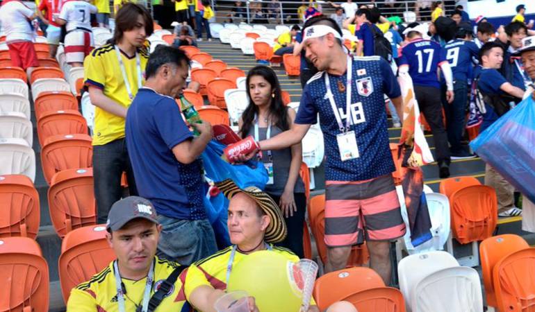 Japoneses y colombianos recogen la basura del estadio.