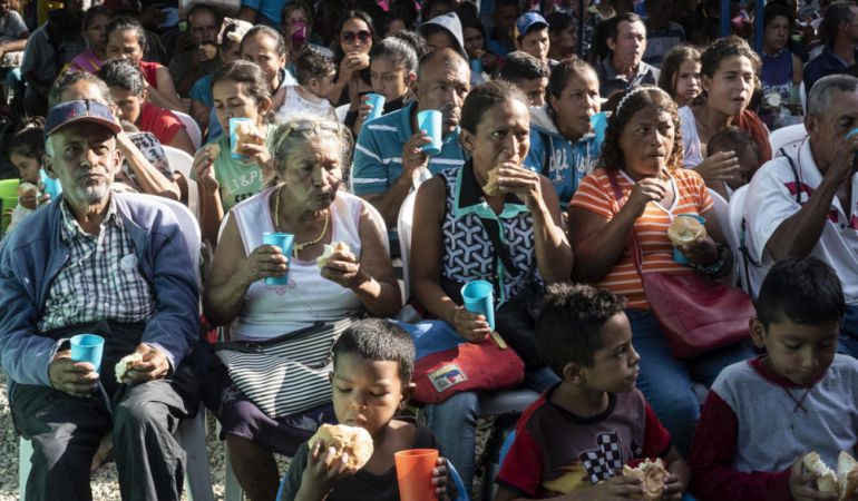 Personas refugiadas y migrantes venezolanas reciben pan en la Casa de Paso Divina Providencia, un centro de alimentación administrado por la Iglesia Católica y apoyado por ACNUR en Cúcuta, Colombia.