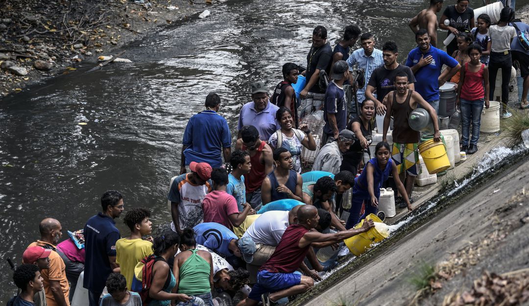Crisis en Venezuela: Caraqueños recogen agua en río contaminado debido a la escasez por apagón