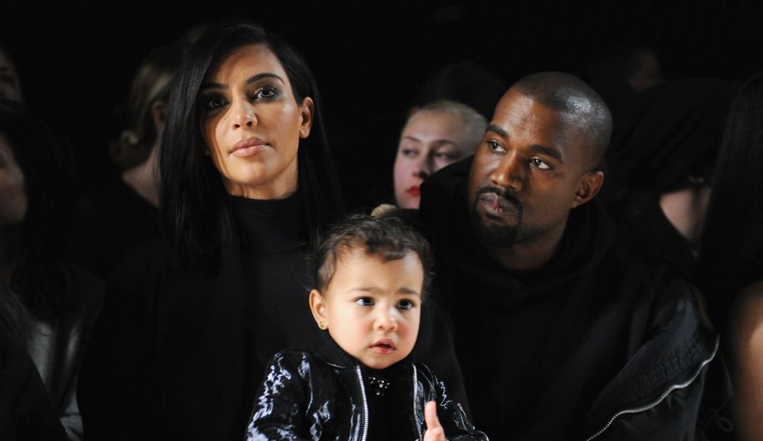 Kim Kardashian con su esposo, junto a uno de sus hijos.