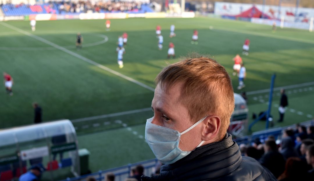 Aficionado del FC Minsk asistiendo a un partido de la Liga de Bielorrusia con un tapabocas.