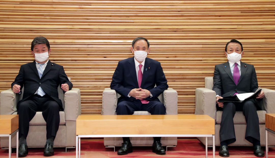 El primer ministro de Japón, Yoshihide Suga, el ministro de Relaciones Exteriores y el ministro de Finanzas,, asisten a una reunión del gabinete en Tokio el 22 de enero de 2021, ya que el primer ministro dijo que estaba "decidido" a celebrar el Tokio. Juegos Olímpicos después de un informe nocturno que afirma que los funcionarios creen que la cancelación es inevitable.