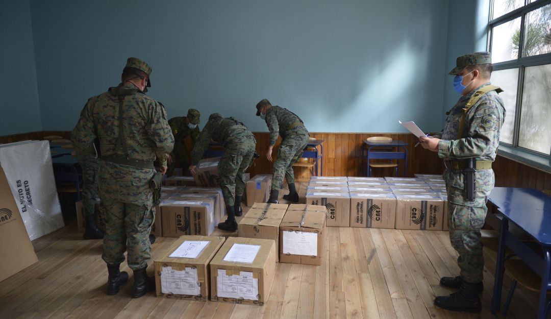 Soldados ecuatorianos trasladan cajas con papeletas electorales a un centro de votación en Quito.