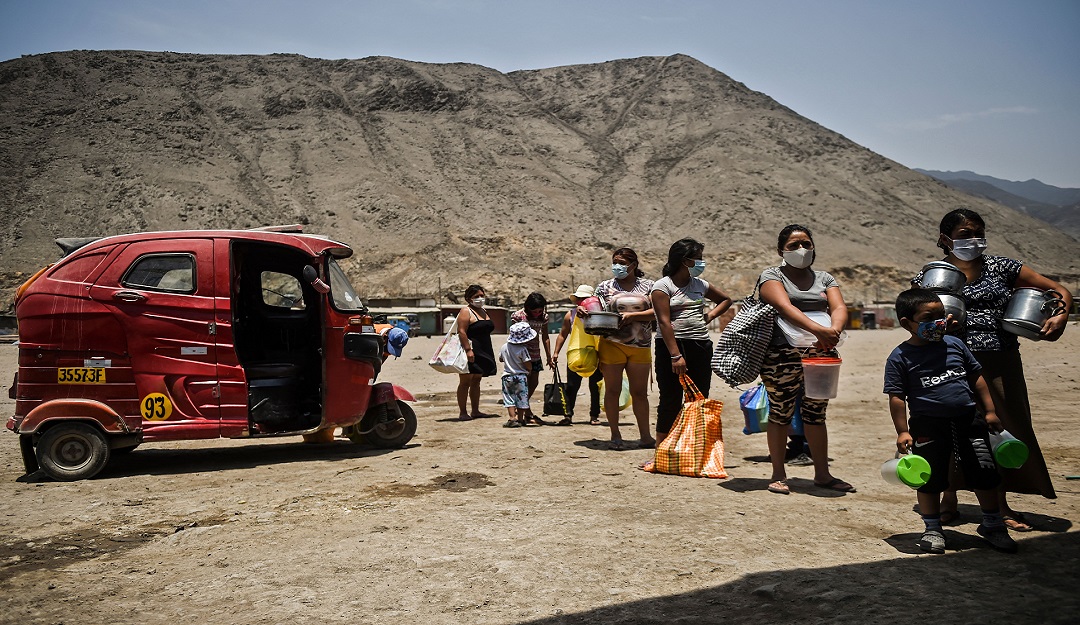 Una comunidad de Comas, al norte de Lima (Perú), mantiene la distancia mientras espera recibir alimentación.