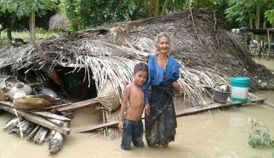 Una mujer y su nieto junto a su casa destruida por las inundaciones que han afectado a Indonesia.