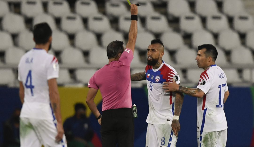 El árbitro Loustau amonesta a Arturo Vidal por protestar durante el juego. El árbitro Loustau amonesta a Arturo Vidal por protestar durante el juego.