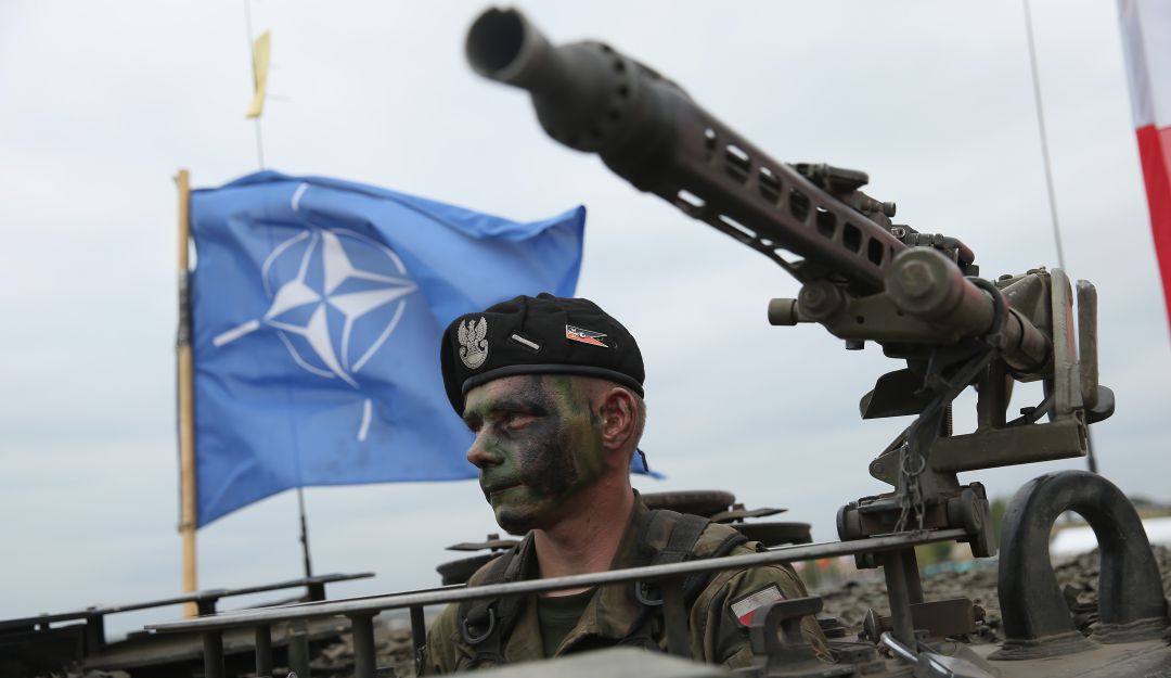 Soldado polaco en un tanque con la bandera de la OTAN. Soldado polaco en un tanque con la bandera de la OTAN.