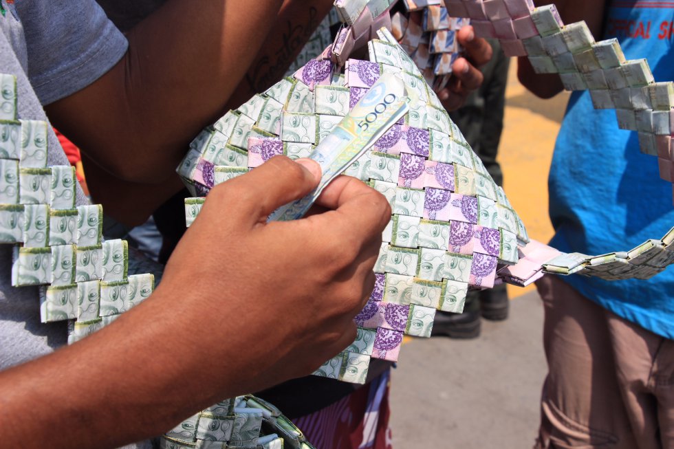 Frente a los ojos del educador Simón Rodríguez, un bolso hecho con billetes de 1.000 y 10.000 bolívares se vende por 5.000 pesos colombianos. Frente a los ojos del educador Simón Rodríguez, un bolso hecho con billetes de 1.000 y 10.000 bolívares se vende por 5.000 pesos colombianos.