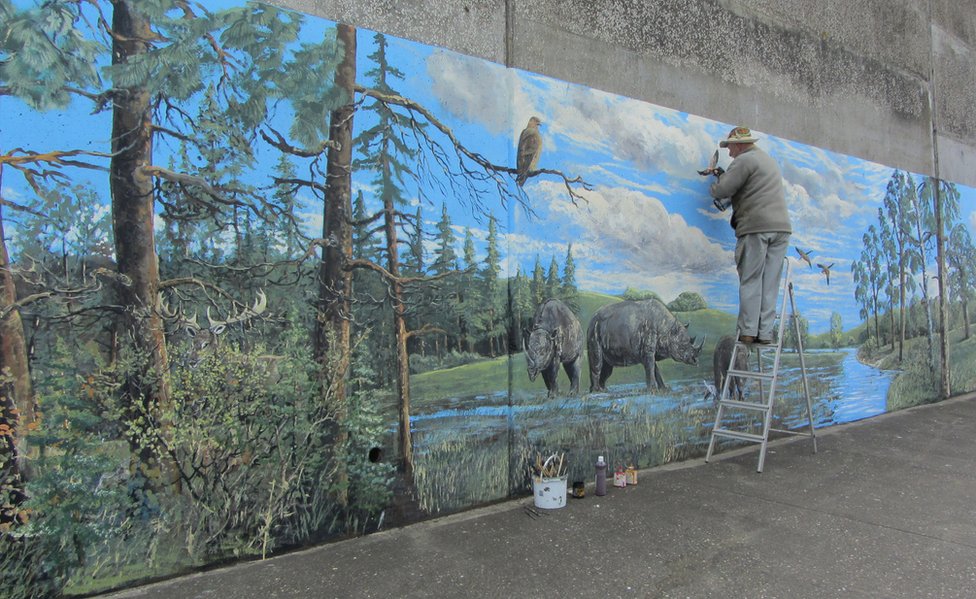 Annette Edgar, este de Inglaterra: "Una familia de rinocerontes presente en el mural de West Runton, pintada en Sheringham (Norfolk) por el artista David Barber, a quien se le ocurrió crear un mural inspirado en el esqueleto de elefante de 700.000 años de West Runton, descubierto en la playa hace 26 años". Annette Edgar, este de Inglaterra: "Una familia de rinocerontes presente en el mural de West Runton, pintada en Sheringham (Norfolk) por el artista David Barber, a quien se le ocurrió crear un mural inspirado en el esqueleto de elefante de 700.000 años de West Runton, descubierto en la playa hace 26 años".