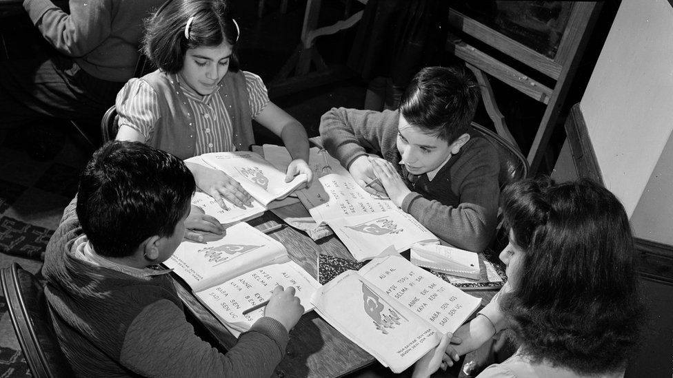 La exposición incluye fotos desde 1940, como esta: “Niños turco-estadounidenses en la mesa con libros de trabajo”. La exposición incluye fotos desde 1940, como esta: “Niños turco-estadounidenses en la mesa con libros de trabajo”.