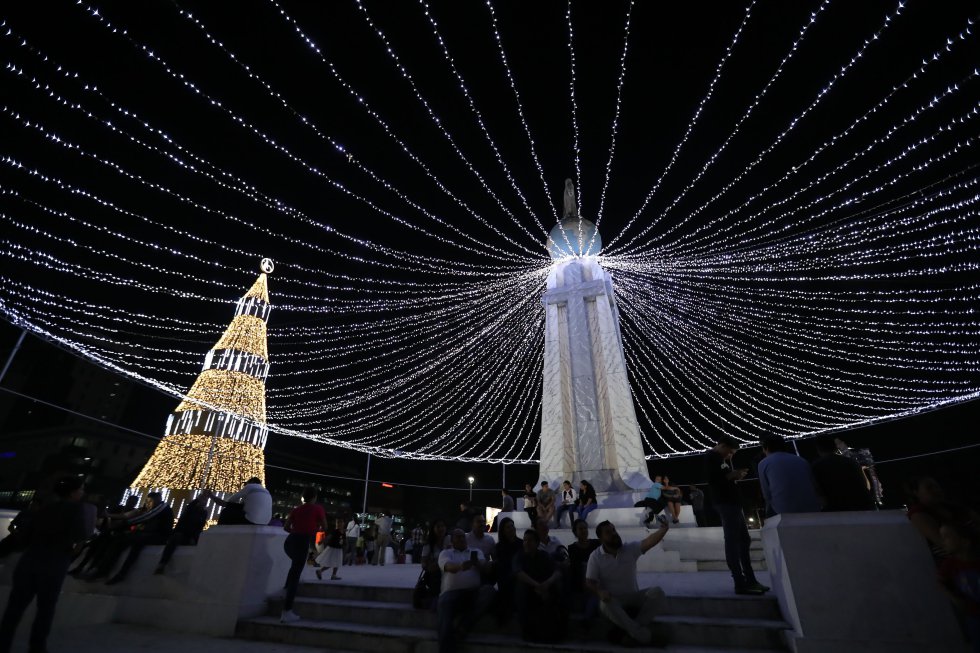 Un grupo de personas celebran el marco del inicio de las fiestas de navidad y de fin de año, en la plaza Salvador del Mundo, en San Salvador. Un grupo de personas celebran el marco del inicio de las fiestas de navidad y de fin de año, en la plaza Salvador del Mundo, en San Salvador.